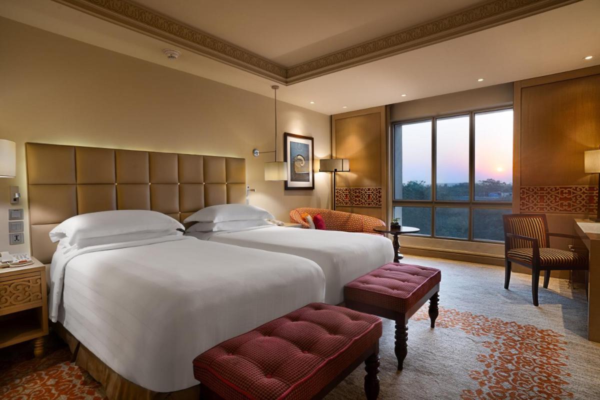 a bedroom with a large bed and a large window at ITC Maratha, a Luxury Collection Hotel, Mumbai in Mumbai