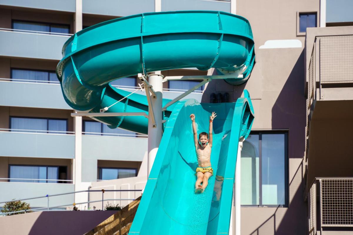 um homem num escorrega num parque aquático em Jupiter Albufeira Hotel - Family & Fun - All Inclusive em Albufeira