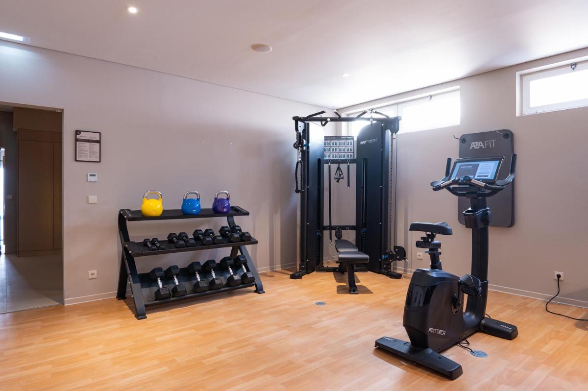 um quarto com um ginásio com muito equipamento de exercício em Vila Gale Collection Figueira da Foz na Figueira da Foz