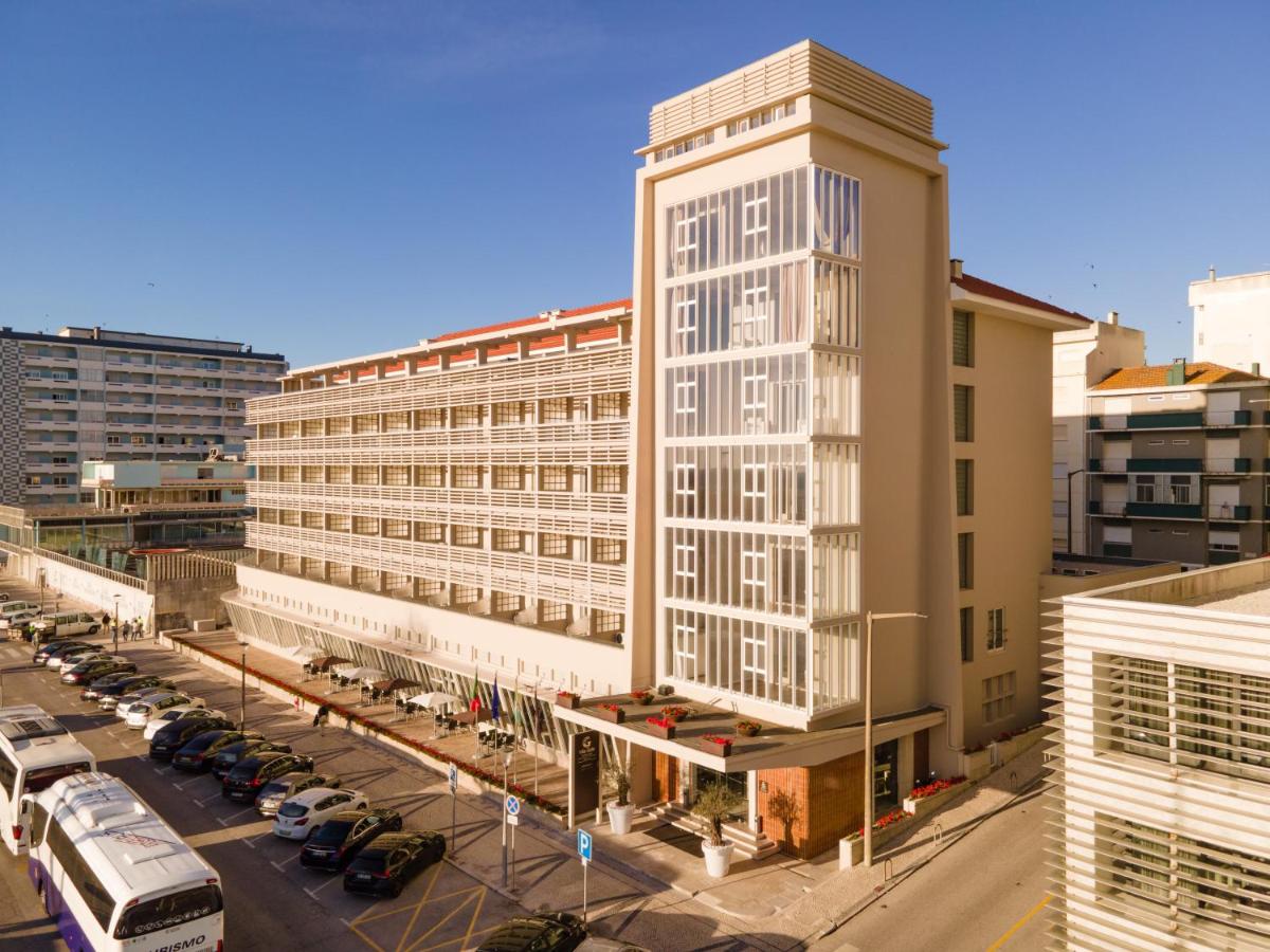 um edifício alto e branco ao lado de um parque de estacionamento em Vila Gale Collection Figueira da Foz na Figueira da Foz