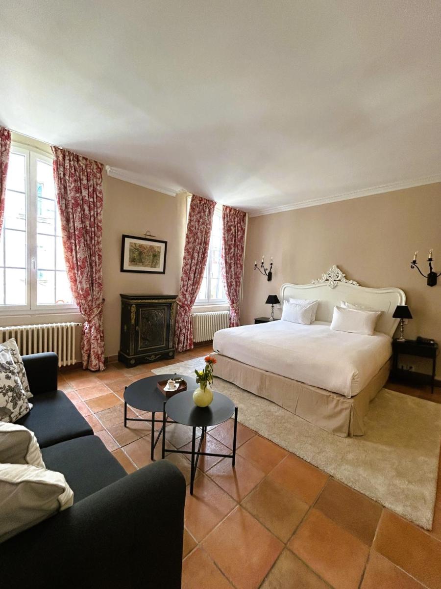 une chambre d'hôtel avec un lit et un canapé dans l'établissement Maison Bérard Hôtel - Restaurant - Spa, à La Cadière-dʼAzur