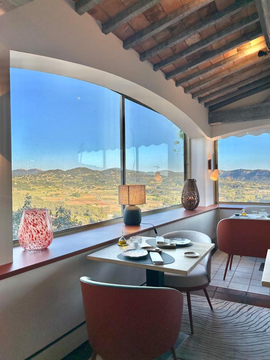 une pièce avec une table et des chaises et une grande fenêtre dans l'établissement Maison Bérard Hôtel - Restaurant - Spa, à La Cadière-dʼAzur