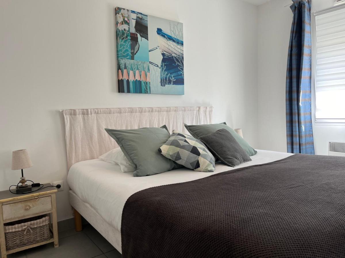 une chambre avec un lit avec des oreillers dessus dans l'établissement Résidence Les Océanes, à Les Sables-dʼOlonne