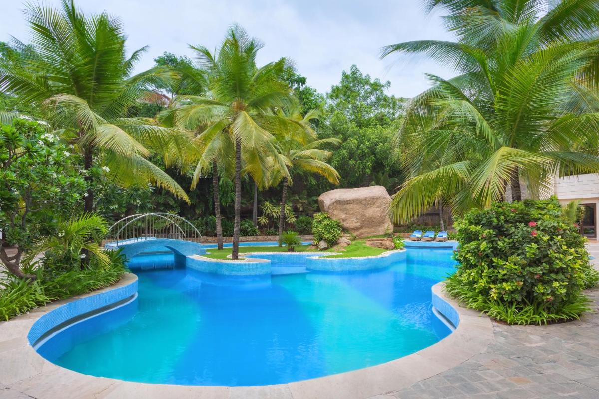 a large pool with palm trees in a resort at ITC Kakatiya, a Luxury Collection Hotel, Hyderabad in Hyderabad
