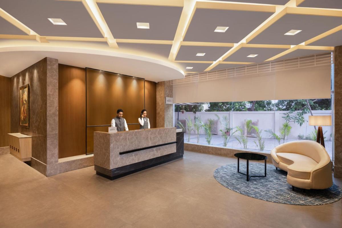 two people standing at a reception desk in a lobby at Fairfield by Marriott Jaipur in Jaipur