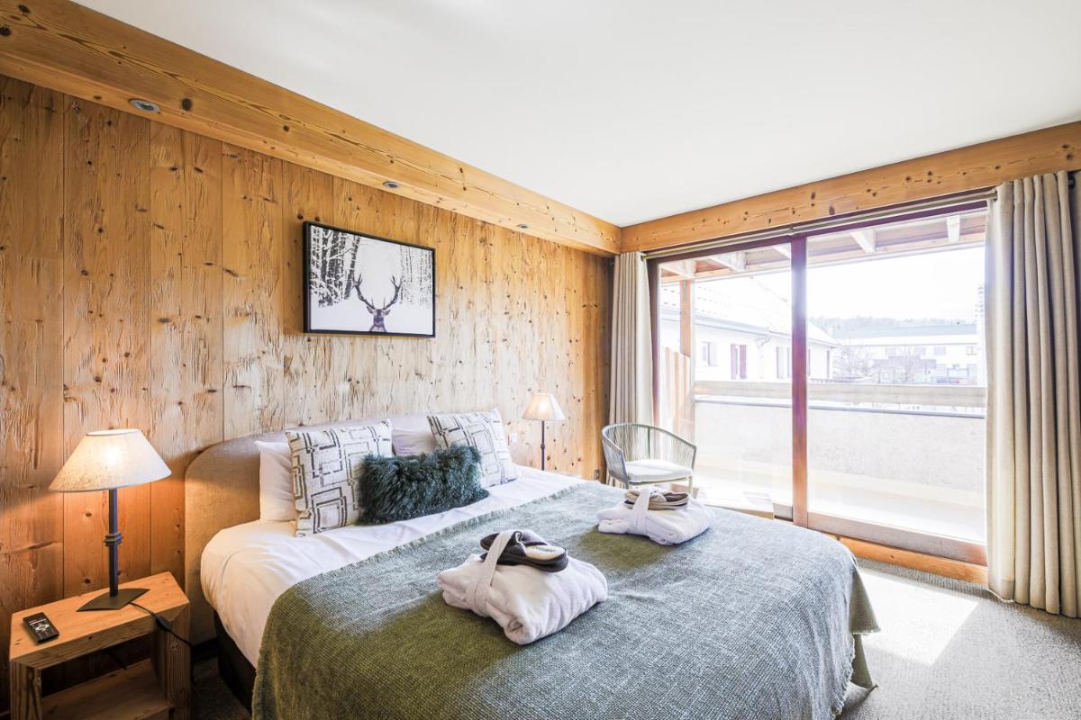 une chambre avec un lit avec des serviettes dessus dans l'établissement Hôtel et Spa les Clarines, à Corrençon-en-Vercors