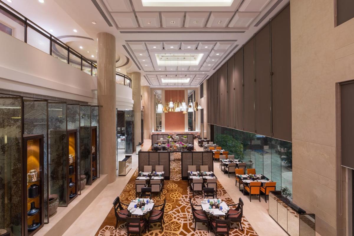 an image of a restaurant with tables and chairs at Sheraton New Delhi Hotel in New Delhi an image of a restaurant with tables and chairs at Sheraton New Delhi Hotel in New Delhi