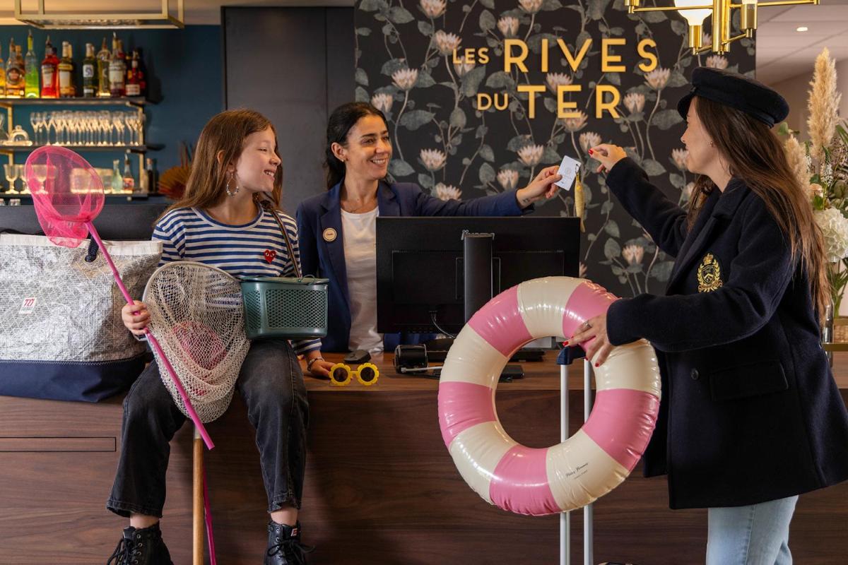un groupe de trois femmes tenant des raquettes et un gilet de sauvetage dans l'établissement Best Western Plus Hotel les Rives du Ter, à Larmor-Plage