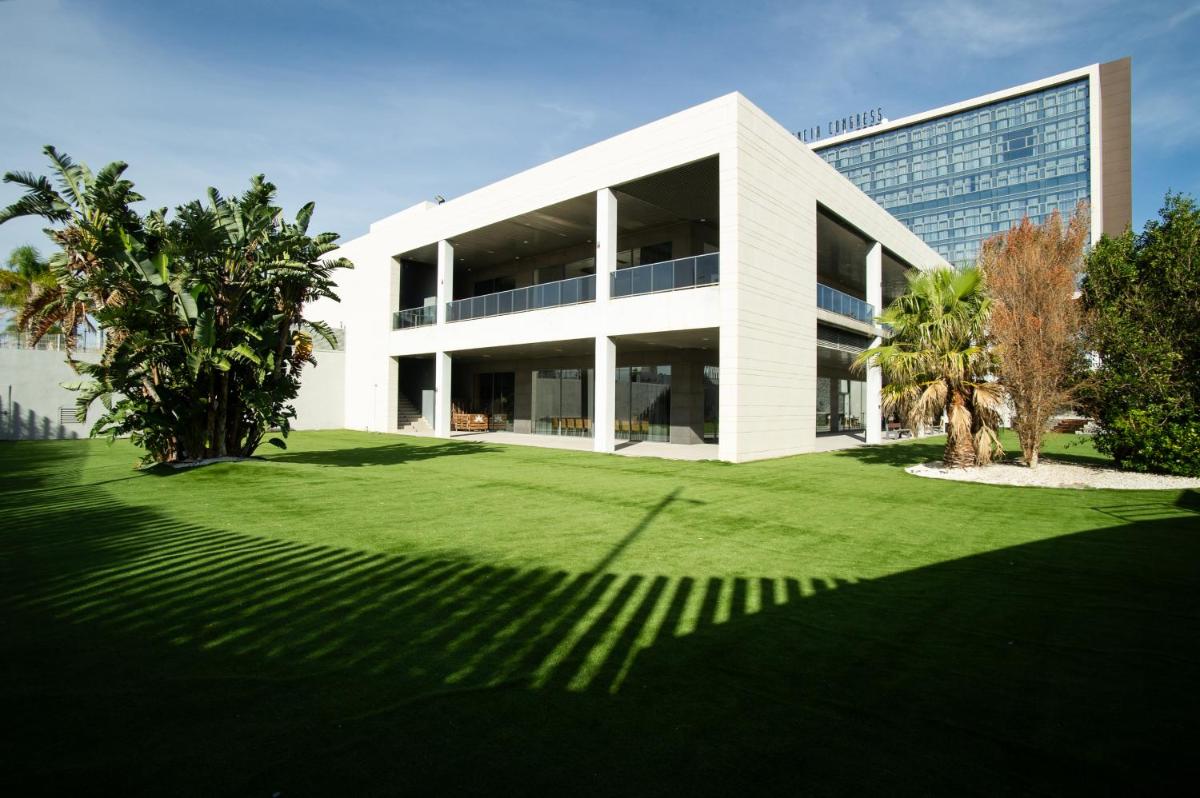 un gran edificio blanco con césped delante en AZZ Valencia Congress Hotel & Spa, en Paterna