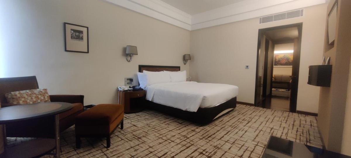a hotel room with a bed and a table at Hotel Marine Plaza in Mumbai