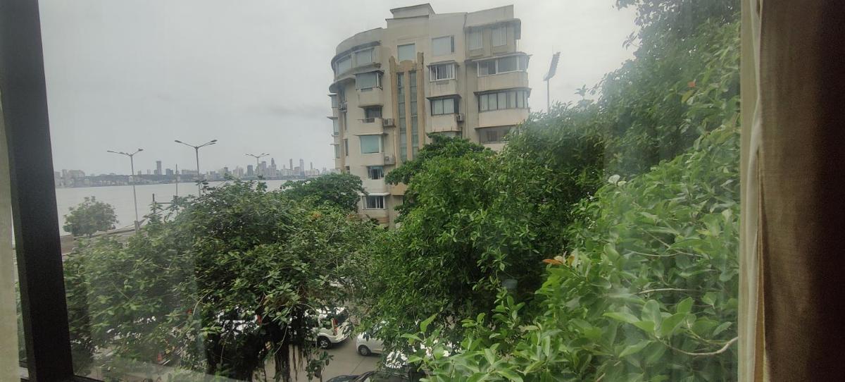a view of a building from a window with trees at Hotel Marine Plaza in Mumbai