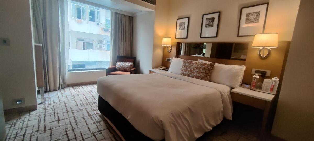 a hotel room with a large bed and a window at Hotel Marine Plaza in Mumbai
