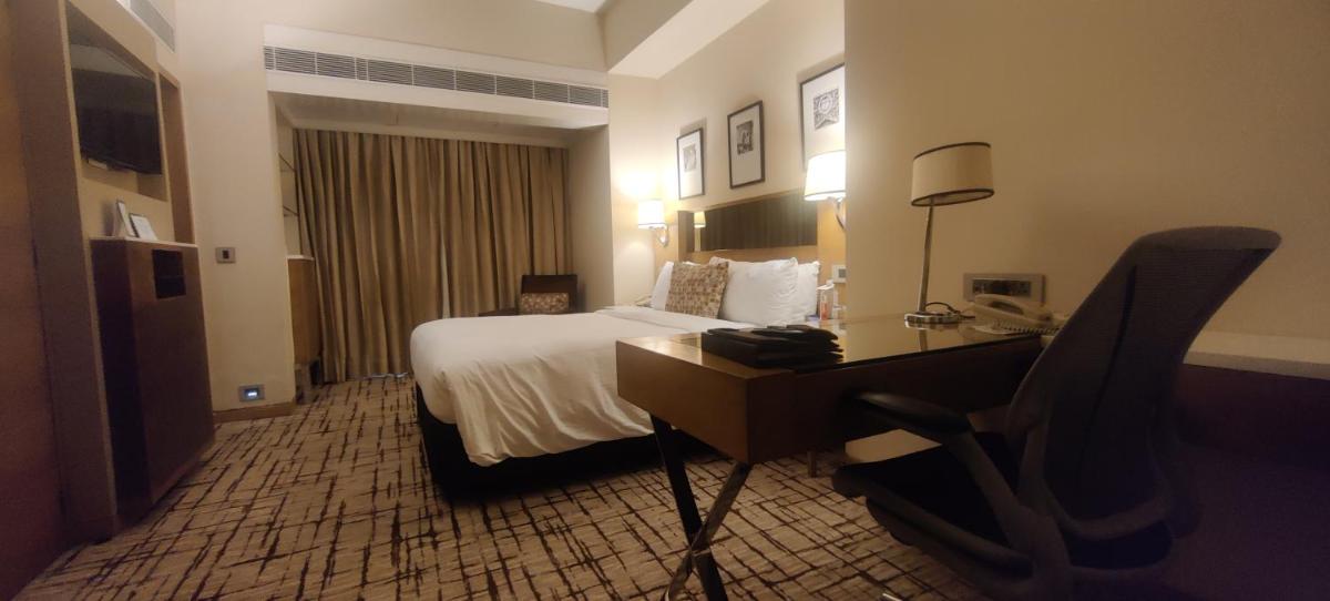 a hotel room with a bed and a desk at Hotel Marine Plaza in Mumbai