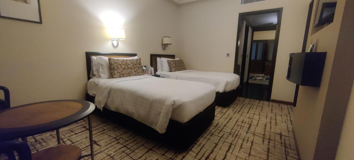 a hotel room with two beds and a television at Hotel Marine Plaza in Mumbai