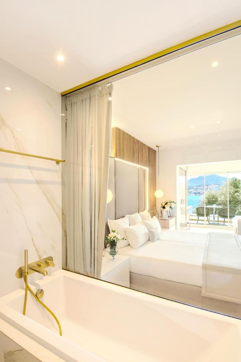 une chambre avec un grand miroir au-dessus d'une baignoire dans l'établissement Hôtel Marinca & Spa, à Olmeto