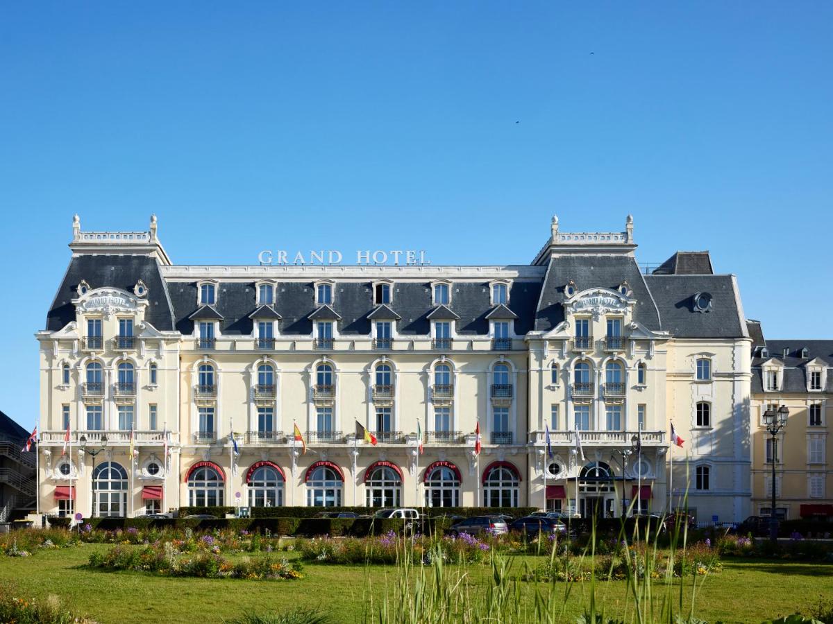 un grand bâtiment blanc avec une enseigne dessus dans l'établissement Le Grand Hotel de Cabourg - MGallery Collection, à Cabourg