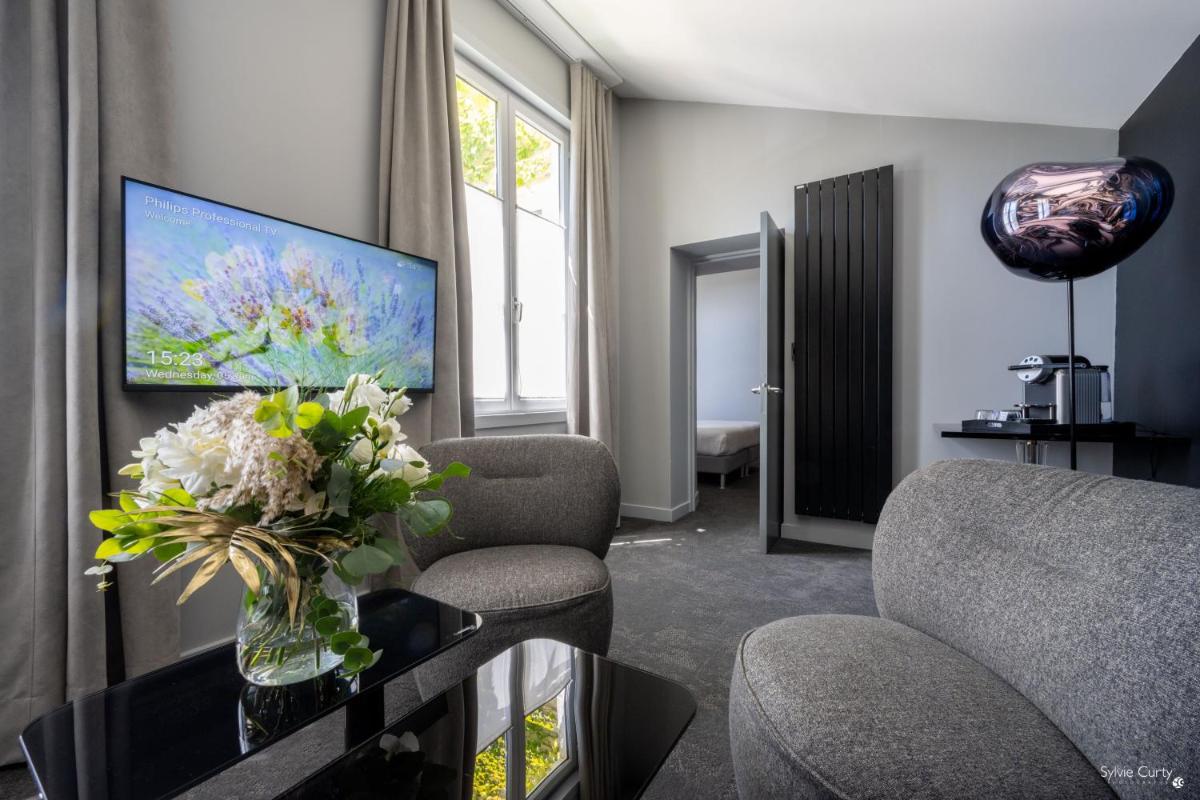 un salon avec un vase de fleurs sur une table dans l'établissement Hôtel La Monnaie Arty & Spa, à La Rochelle