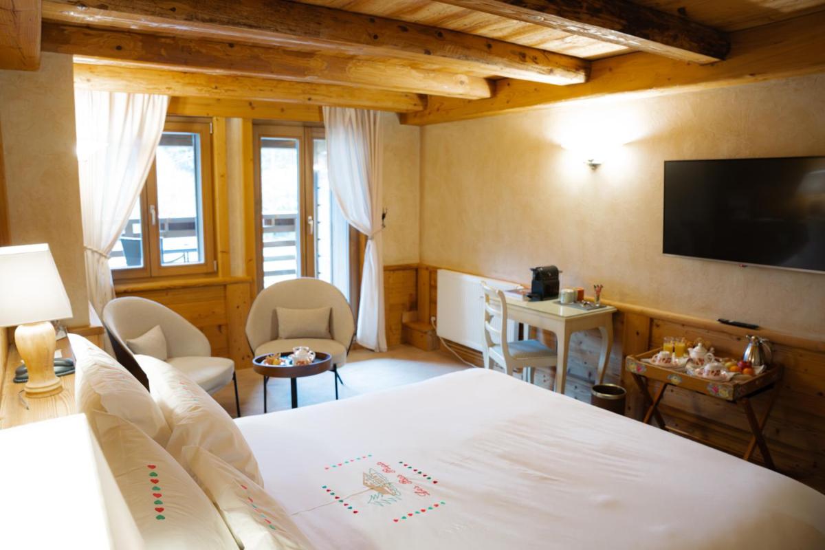une chambre d'hôtel avec un lit et une télévision dans l'établissement Hôtel-Restaurant Les Bas-Rupts, Singuliers Hôtel, à Gérardmer