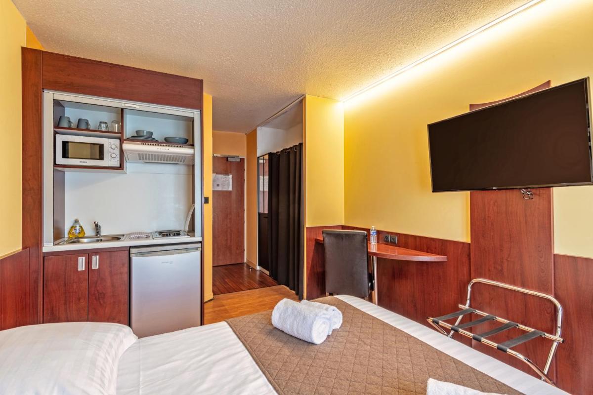 Un ou plusieurs lits dans un hébergement de l'établissement Logis Hotel Center