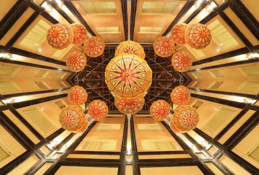 a bunch of colorful lights hanging from a ceiling at Golden Tulip Jaipur in Jaipur