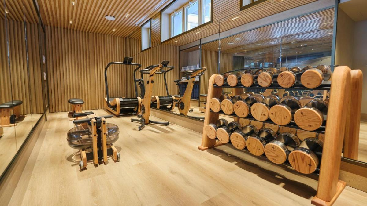 Un gimnasio con máquinas de ejercicio y pisos de madera. en ESTIMAR Valencia, en Valencia