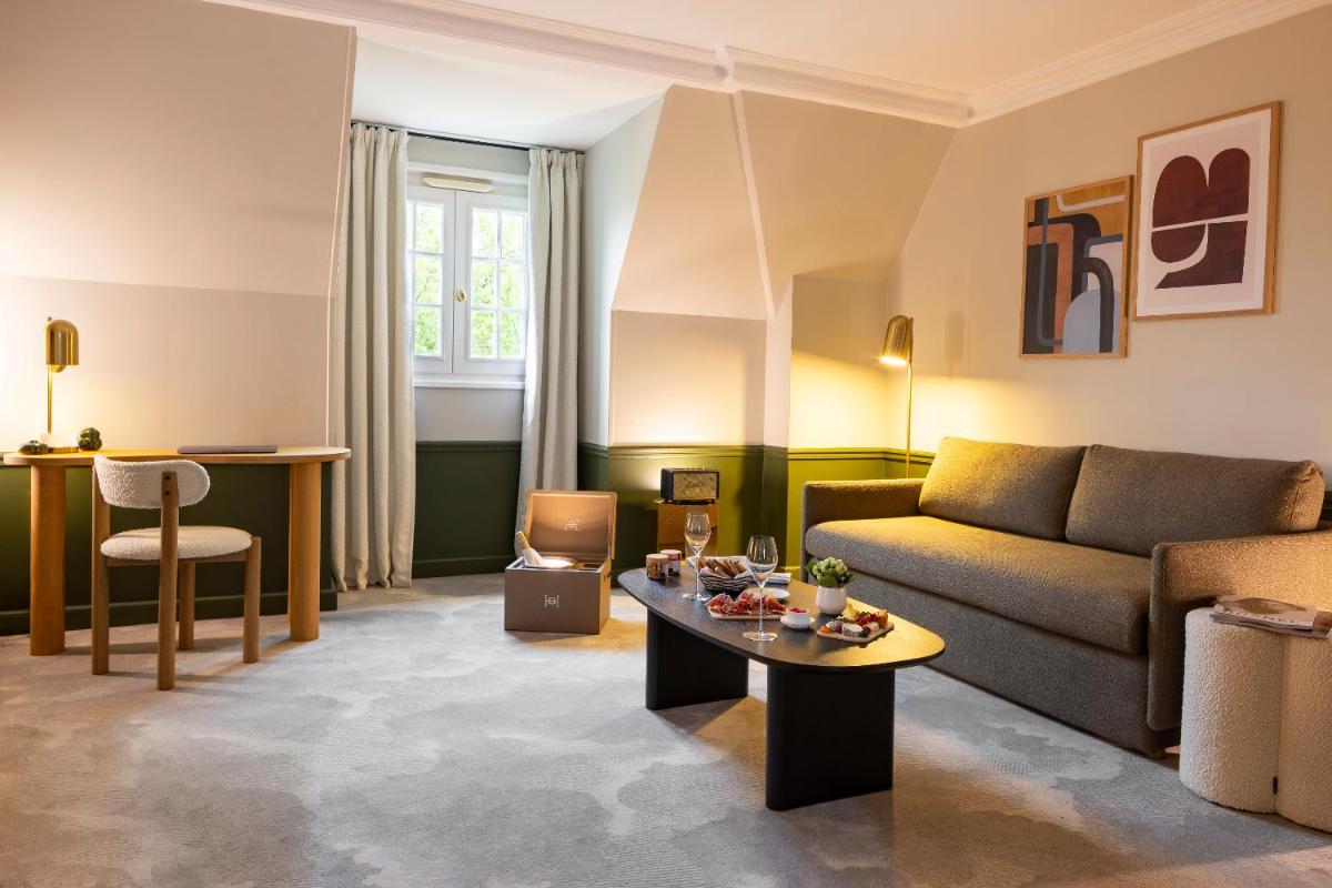 un salon avec un canapé et une table dans l'établissement Briqueterie Champagne, A Beauvallon Hotel & Spa, à Vinay
