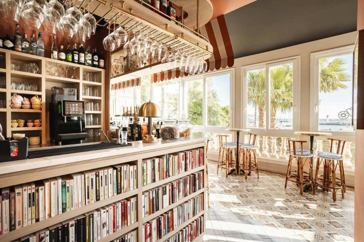 une bibliothèque avec des étagères remplies de livres dans l'établissement Villa Camille Hotel & Spa, à Banyuls-sur-Mer