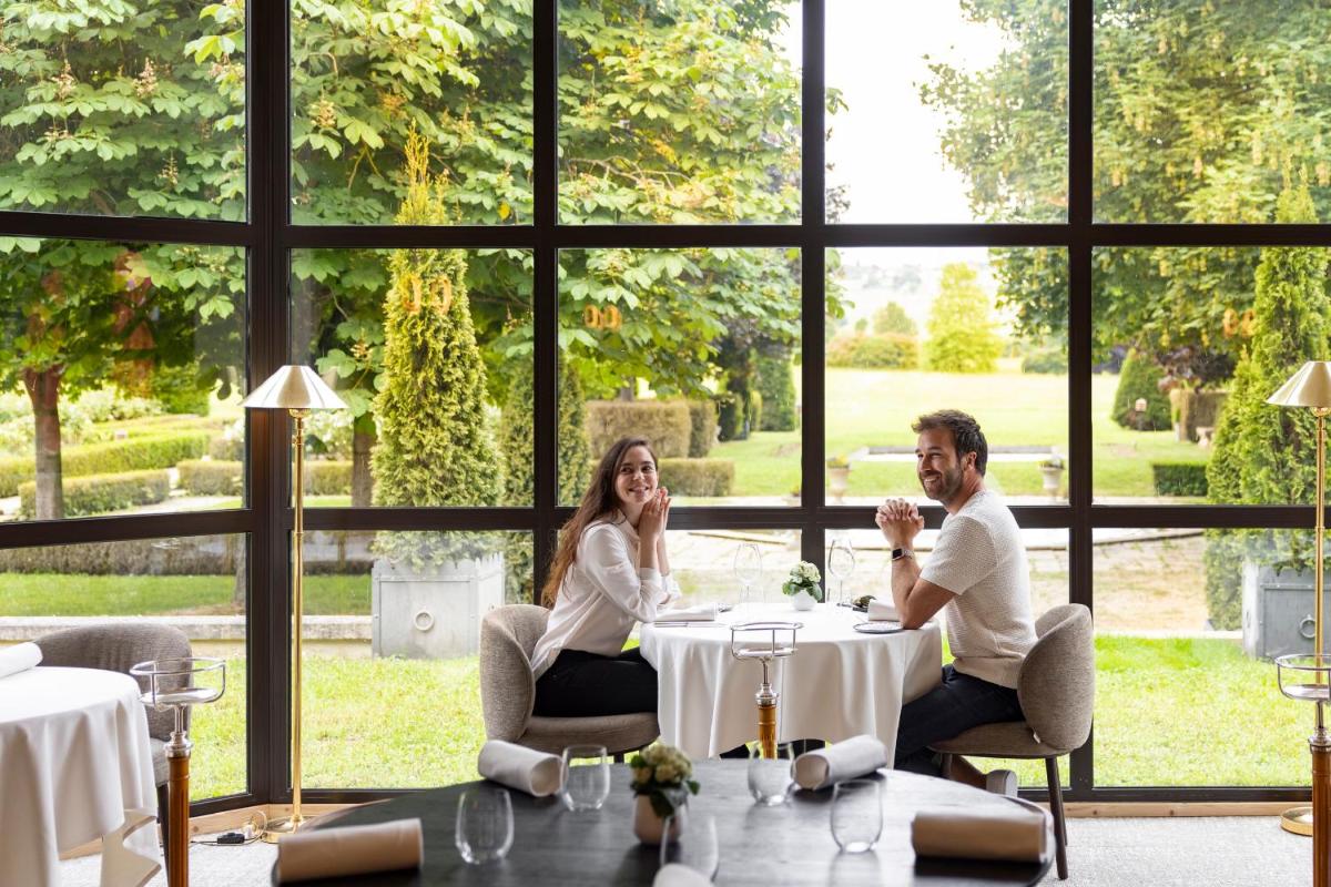 un homme et une femme assis à une table dans un restaurant dans l'établissement Briqueterie Champagne, A Beauvallon Hotel, à Vinay 37 autres photos