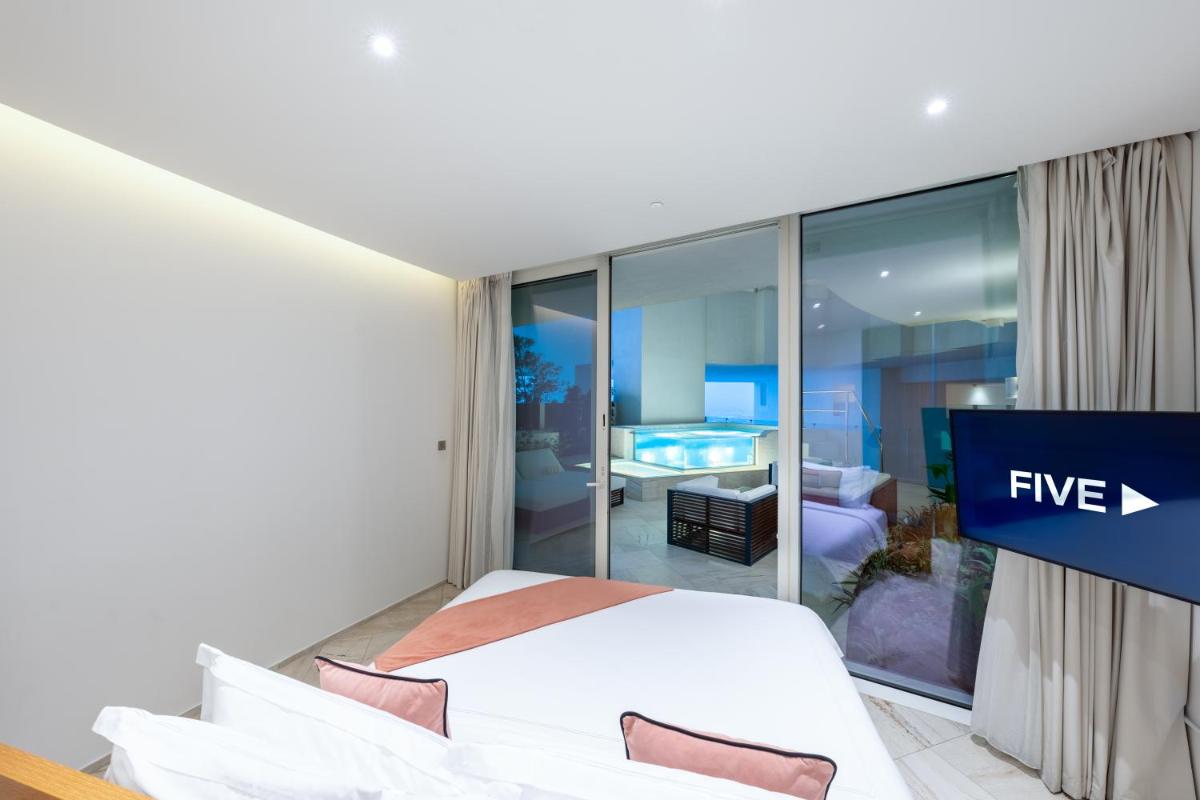a hotel room with a bed and a tv at FIVE Jumeirah Village in Dubai