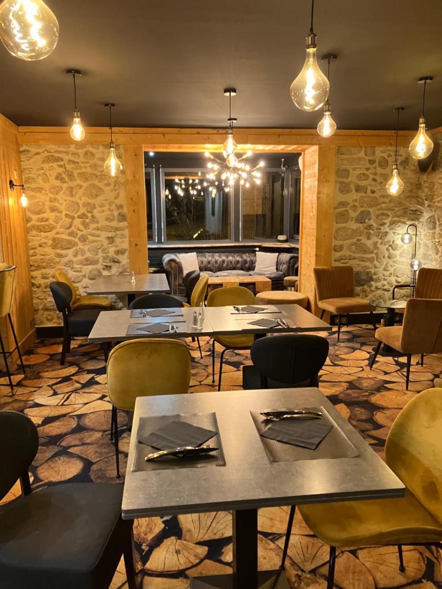 un restaurant avec des tables, des chaises et des lumières dans l'établissement Joy Villard de Lans, à Villard-de-Lans