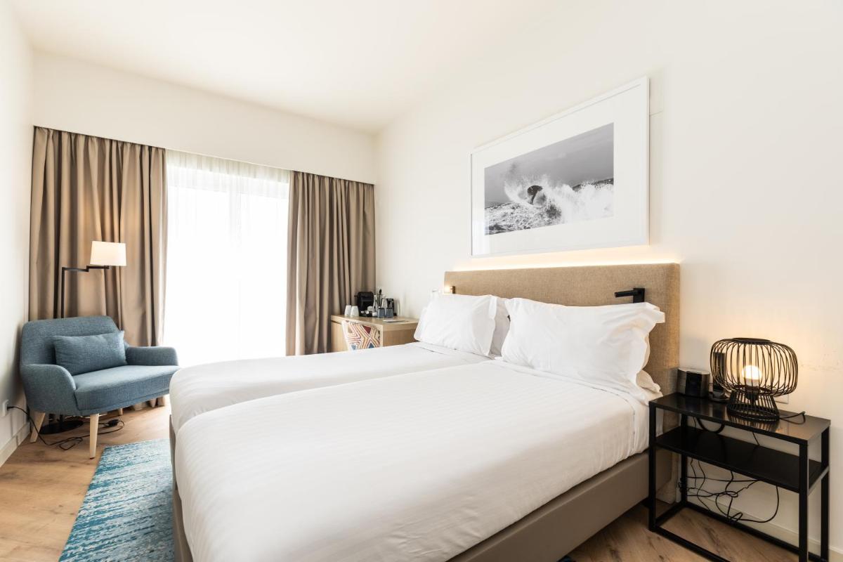 Uma cama ou camas num quarto em Crowne Plaza - Caparica Lisbon