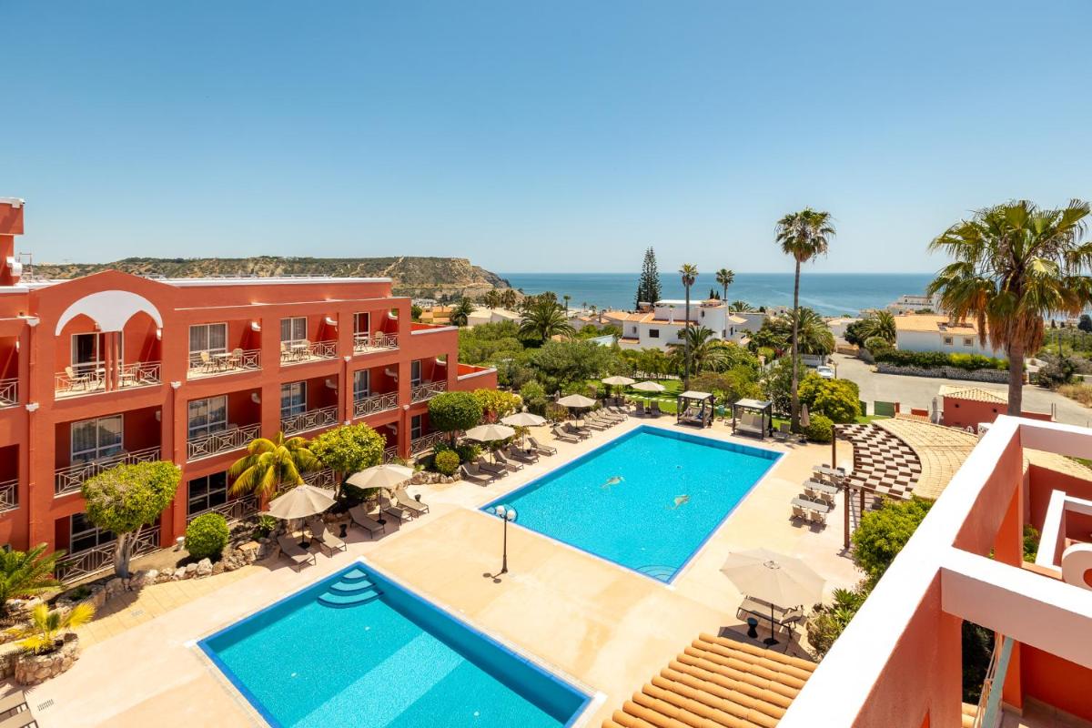 uma vista aérea de um resort com piscina e o oceano em Belavista Da Luz - Wellness & Lifestyle Hotel na Praia da Luz