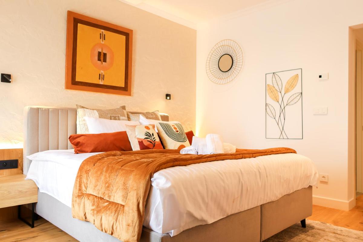 une chambre avec un grand lit et des oreillers orange dans l'établissement Les Rêveries du Clos POMMARD Vignes & SPA& Dégustation, à Pommard