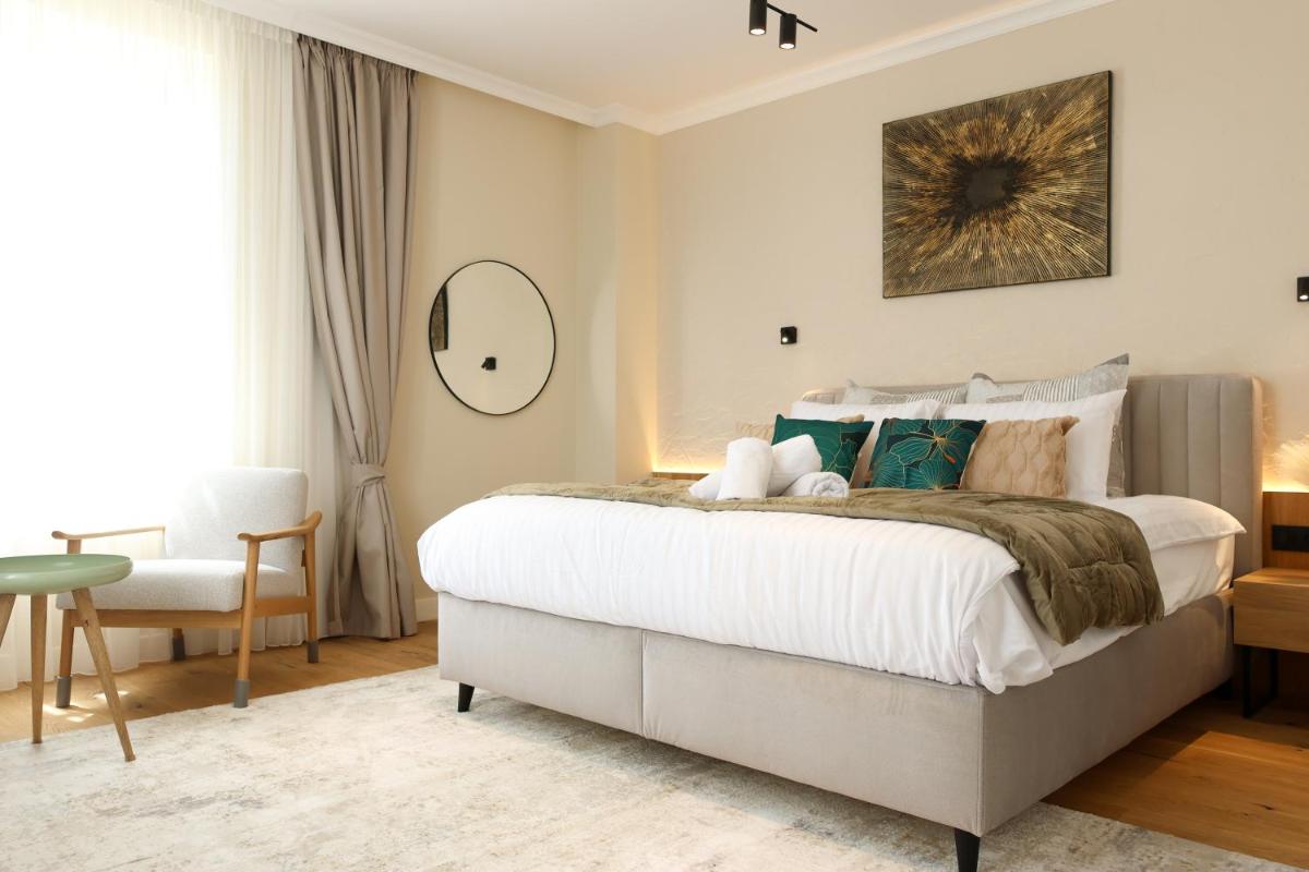 une chambre avec un grand lit blanc et une chaise dans l'établissement Les Rêveries du Clos POMMARD Vignes & SPA& Dégustation, à Pommard