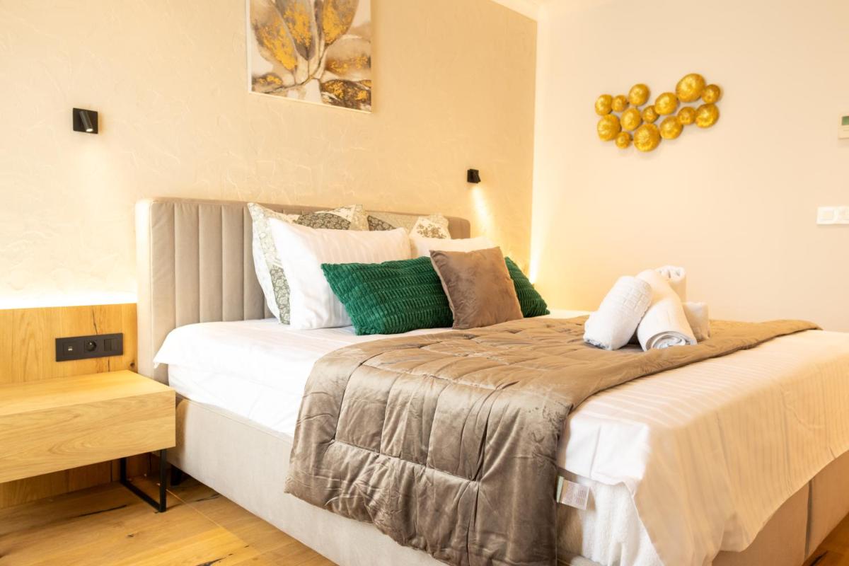 une chambre avec un grand lit aux oreillers verts et blancs dans l'établissement Les Rêveries du Clos POMMARD Vignes & SPA& Dégustation, à Pommard 97 autres photos