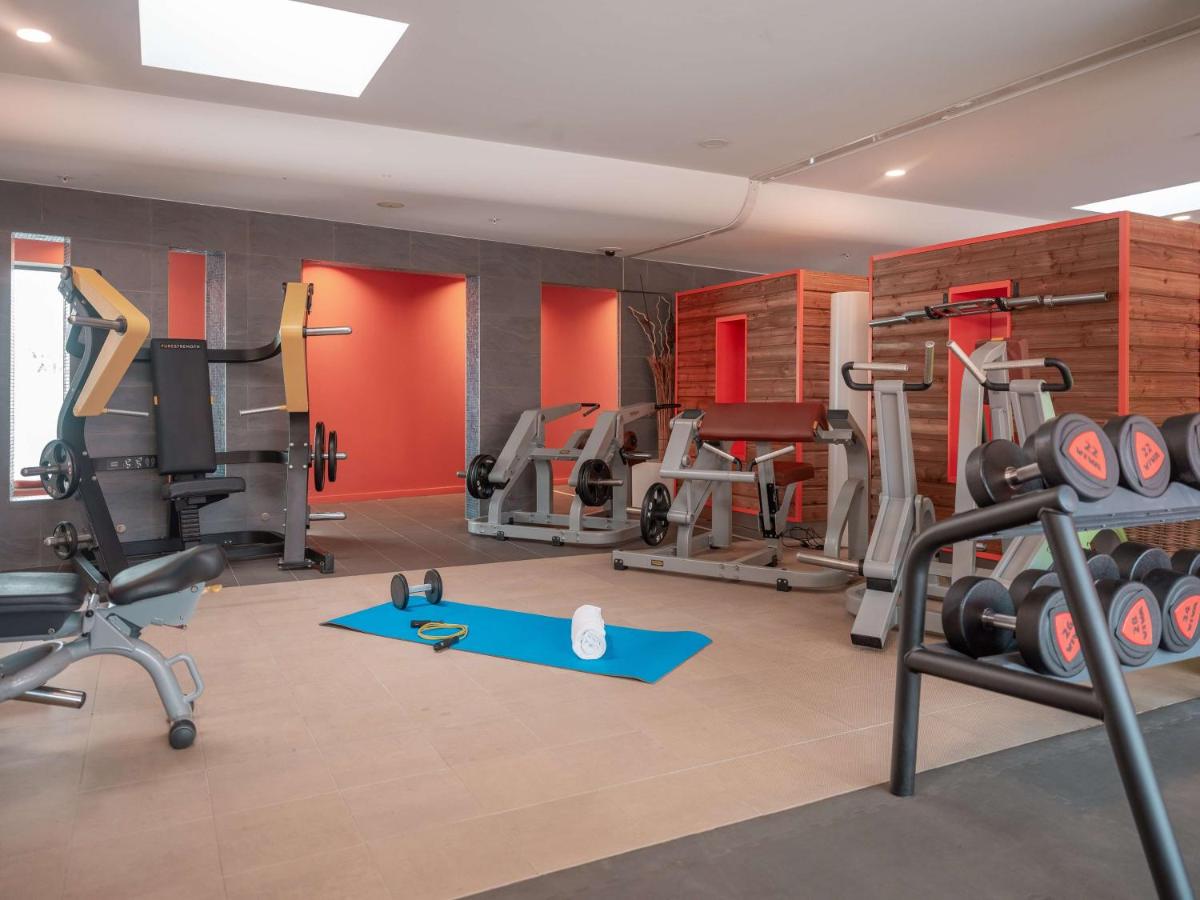 - une salle de sport avec plusieurs tapis de course et machines dans l'établissement Radisson Blu Hotel Toulouse Airport, à Blagnac