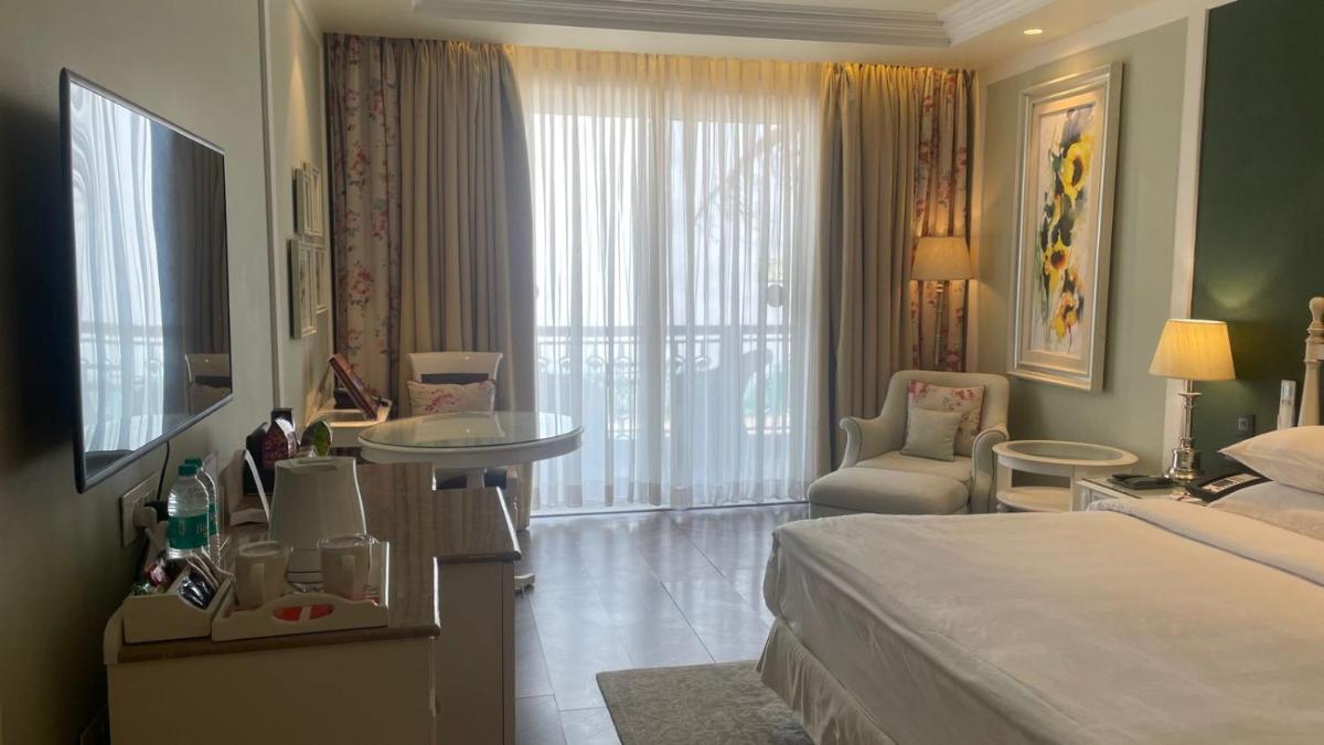 a hotel room with a large bed and a bathroom at Welcomhotel by ITC Hotels, The Savoy, Mussoorie in Mussoorie