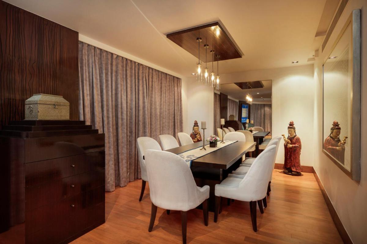 a dining room with a long table and white chairs at InterContinental Marine Drive Mumbai by IHG in Mumbai