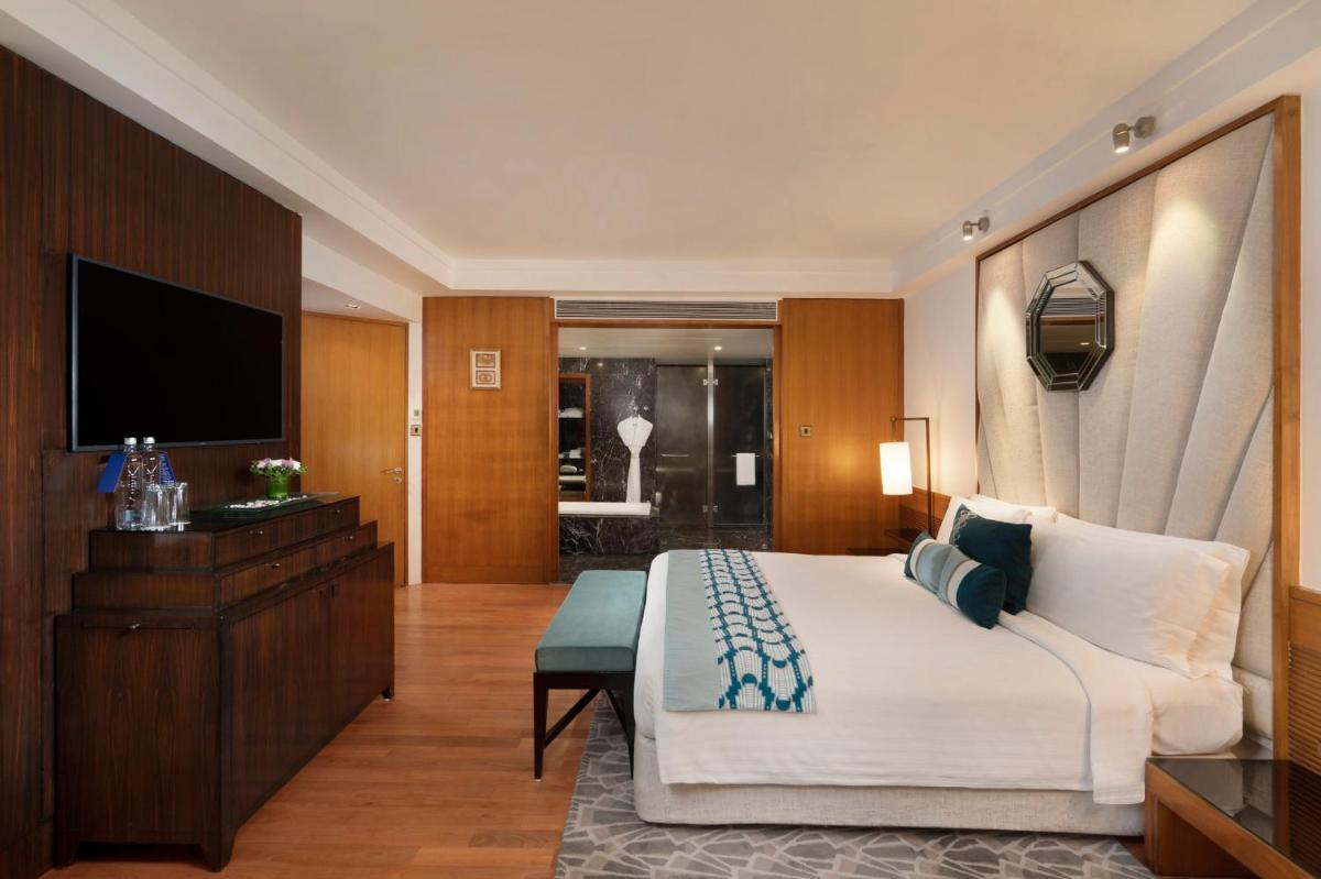 a hotel room with a large bed and a television at InterContinental Marine Drive Mumbai by IHG in Mumbai