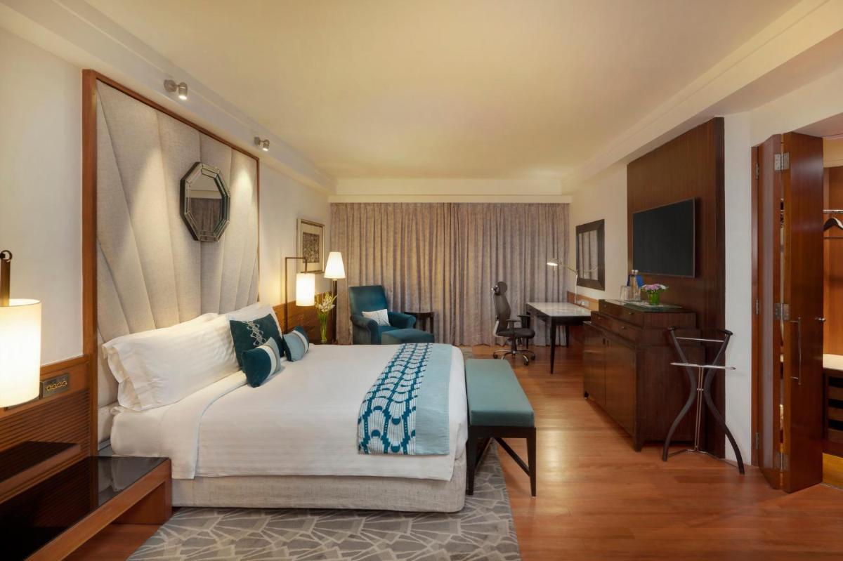 a hotel room with a large bed and a desk at InterContinental Marine Drive Mumbai by IHG in Mumbai