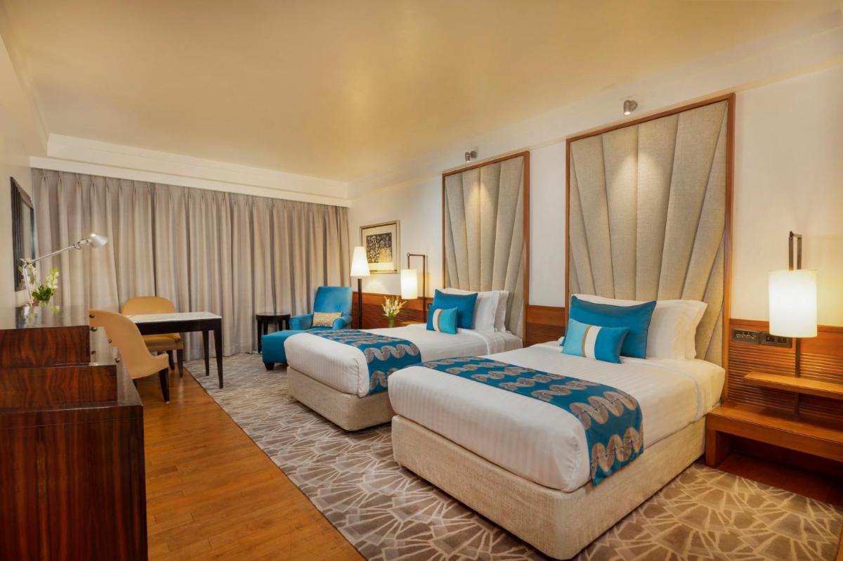 a hotel room with two beds and a desk at InterContinental Marine Drive Mumbai by IHG in Mumbai