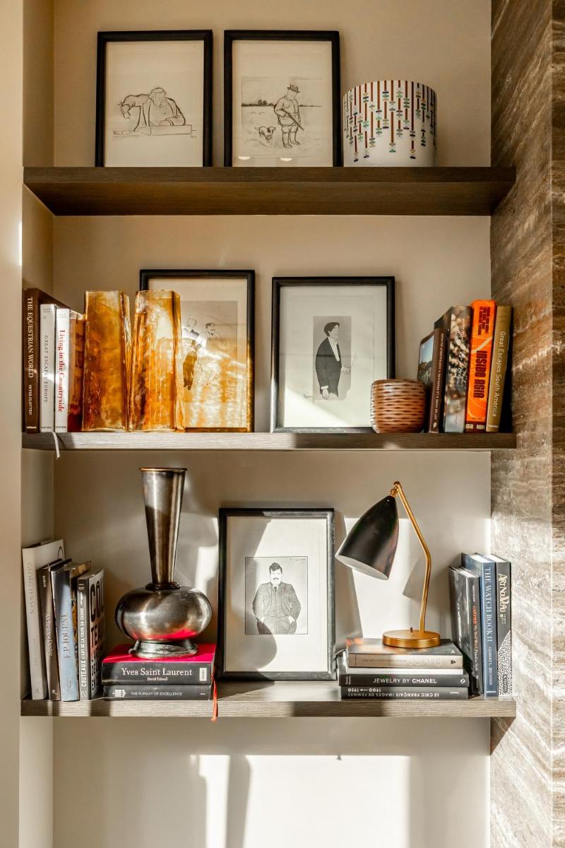 une étagère avec des livres, des photos et une lampe dans l'établissement Maison Boissière BARNES Residences, à Paris 37 autres photos
