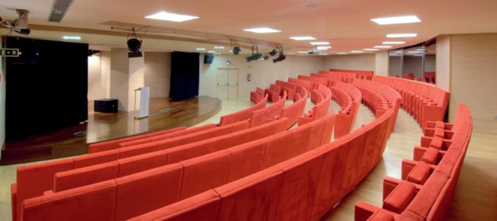Un auditorio vacío con sillas rojas en una habitación. en Ohtels Les Oliveres, en Perelló 30 fotos más