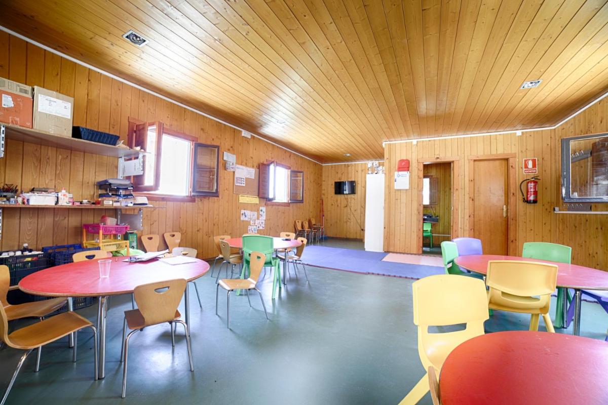 una habitación con mesas y sillas en un aula en Ohtels Les Oliveres, en Perelló