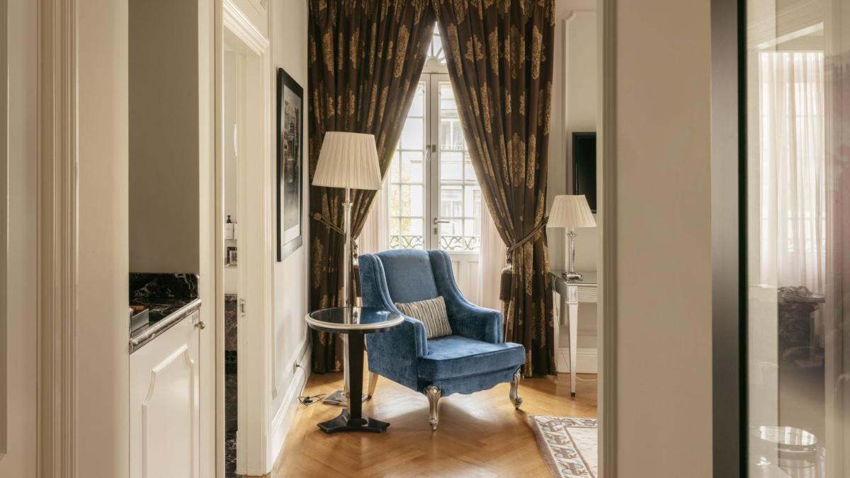 uma sala de estar com uma cadeira azul e uma janela em InterContinental Porto - Palacio das Cardosas by IHG no Porto
