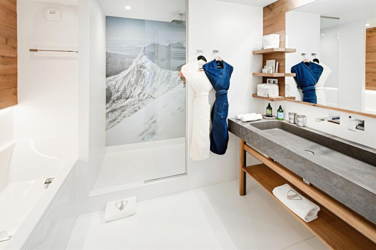 une salle de bain avec un lavabo et un miroir dans l'établissement Hotel Pashmina Le Refuge, à Val Thorens