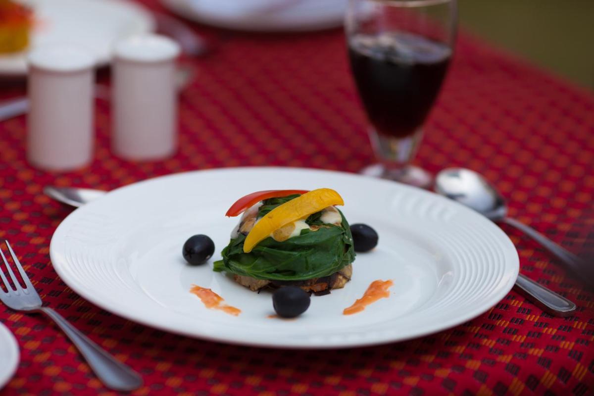 a plate of food on a table with a glass of soda at The Grand Imperial - Heritage Hotel in Agra