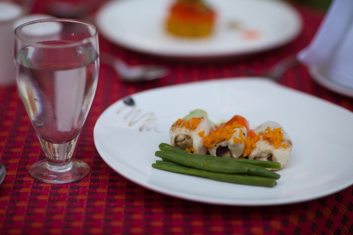 a plate of food on a table next to a glass at The Grand Imperial - Heritage Hotel in Agra