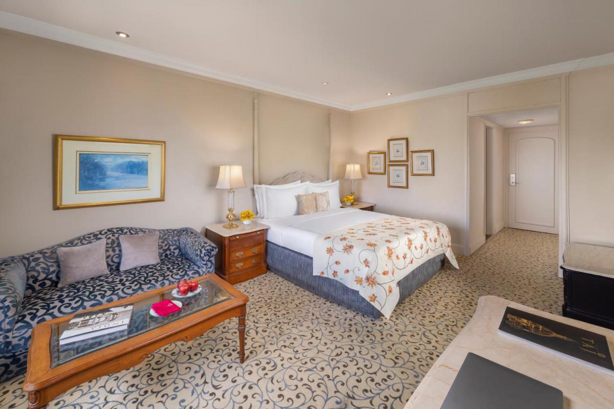 a hotel room with a bed and a couch at Taj Palace, New Delhi in New Delhi a hotel room with a bed and a couch at Taj Palace, New Delhi in New Delhi