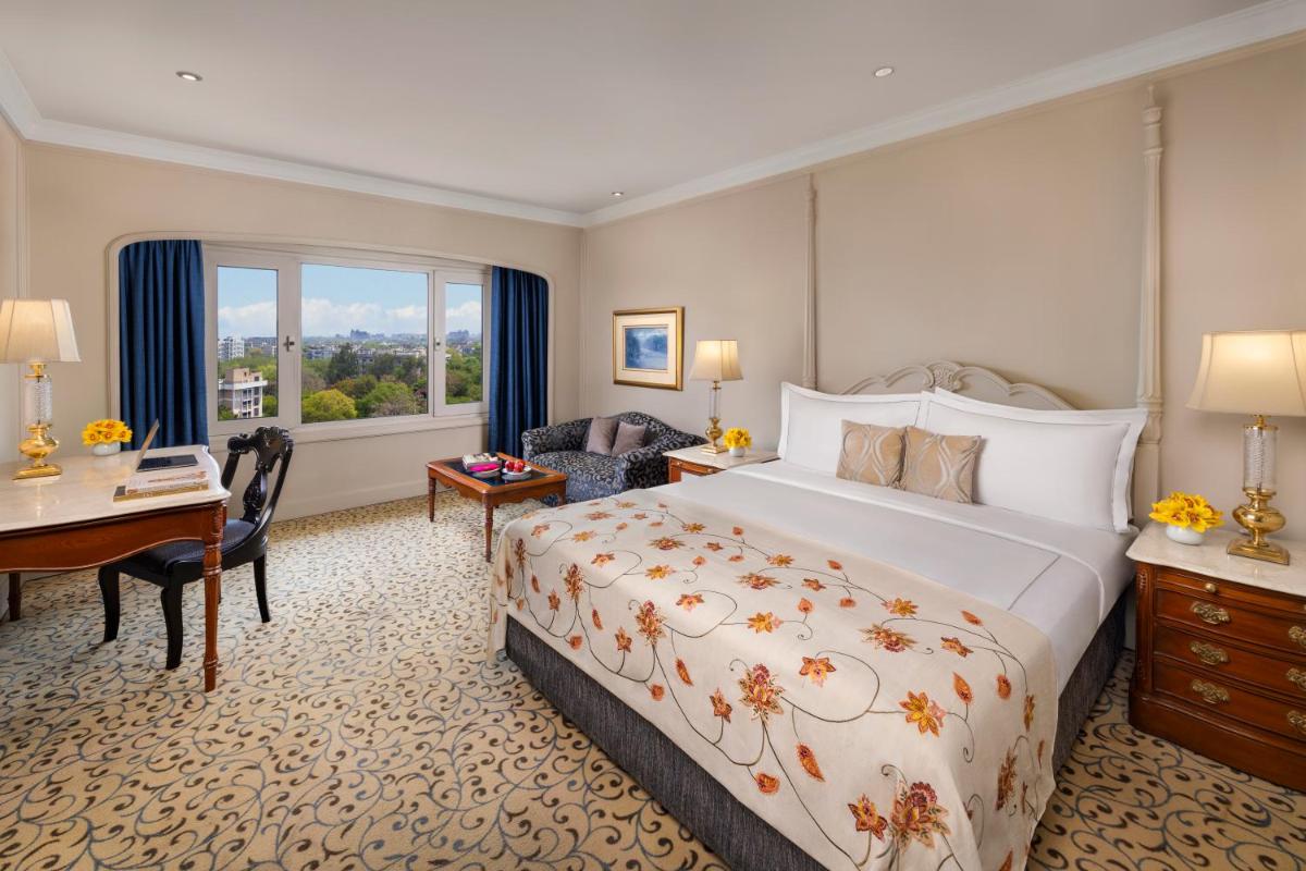 a hotel room with a large bed and a desk at Taj Palace, New Delhi in New Delhi a hotel room with a large bed and a desk at Taj Palace, New Delhi in New Delhi